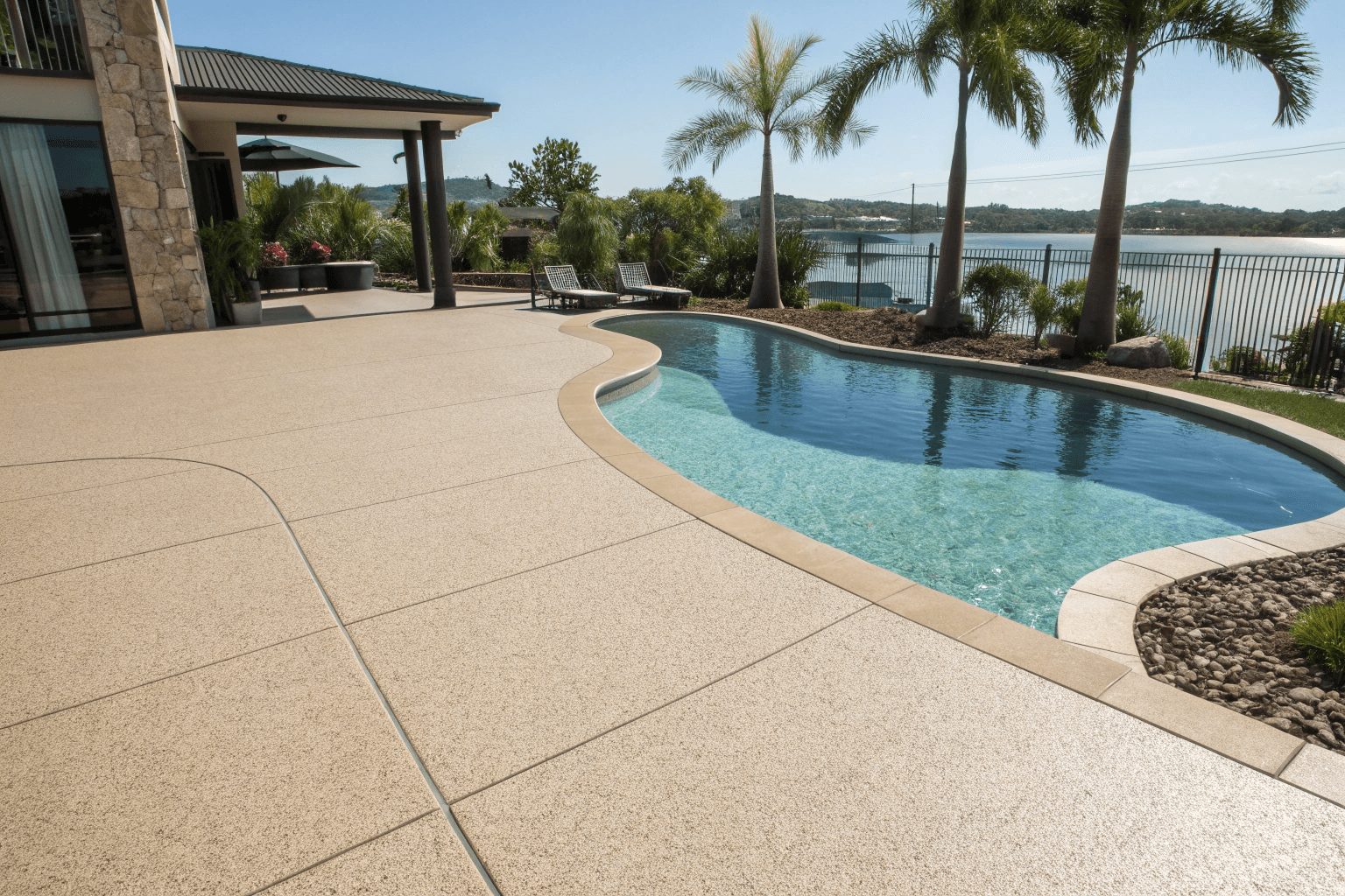 Slip-resistant pool deck epoxy applications on Sunshine Coast home showing textured surface around swimming pool for safe barefoot walking
